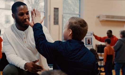 A Benedictine graduate works with a child at a community center